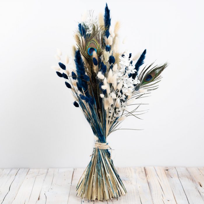 Trockenblumenstrauß mit Pfauenfeder, blauen und naturfarbenen Gräsern, hoch und gestaffelt gebunden